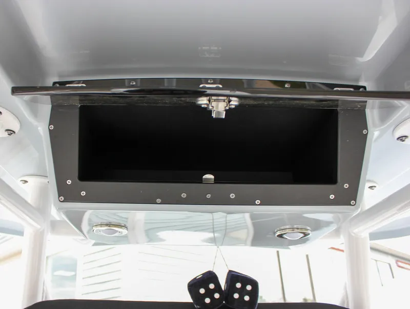 Slide: The Image of 2023 Blackfin 252 CC boat storage compartment with open hatch and hanging dice. - 42