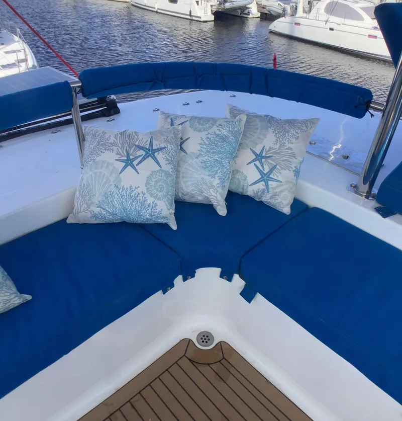 Slide: The Image of 2021 Royal Cape Catamarans Majestic 570 Flybridge with blue seating and decorative pillows. - 24