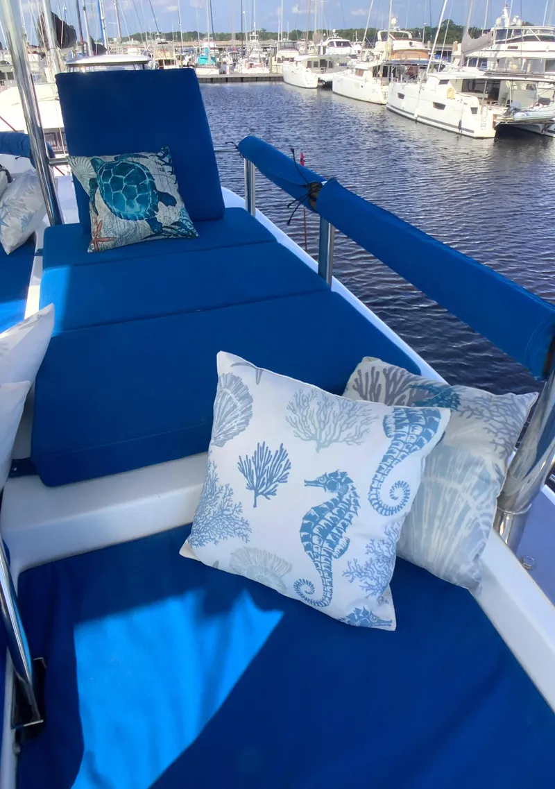 Slide: The Image of Flybridge of 2021 Royal Cape Catamarans Majestic 570 with blue cushions and nautical-themed pillows. - 27