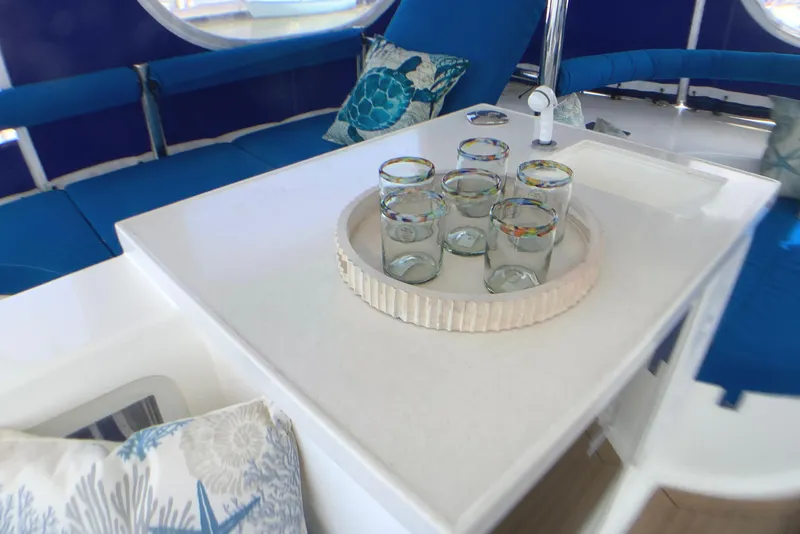 Slide: The Image of Luxurious interior of 2021 Royal Cape Catamarans Majestic 570 Flybridge with glassware and cushions. - 29