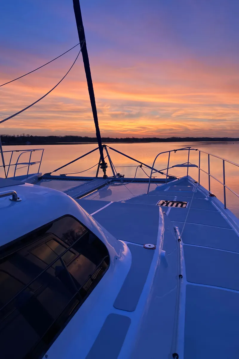 Slide: The Image of 2021 Royal Cape Catamarans Majestic 570 Flybridge at sunset, serene waters, vibrant sky. - 3