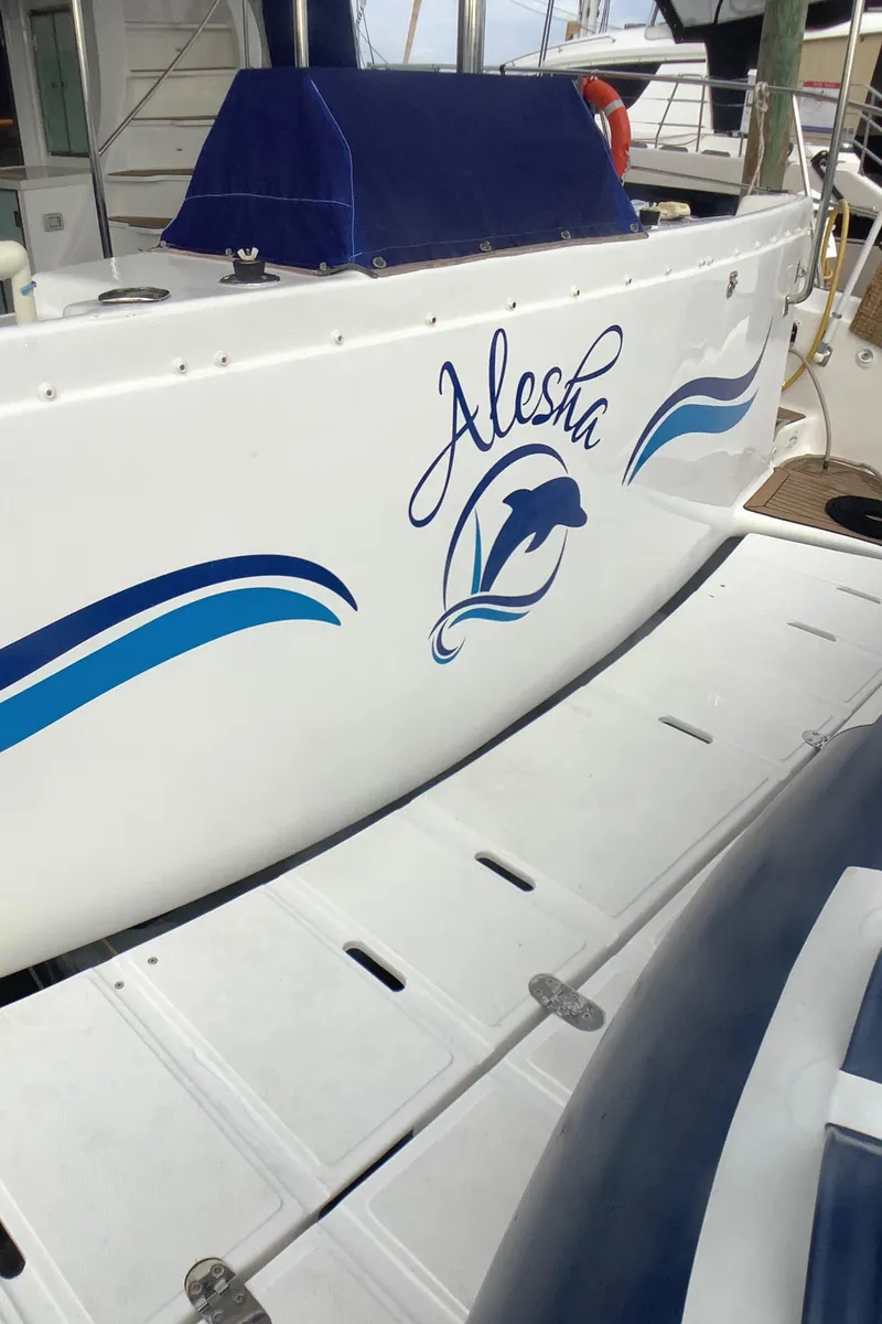 Slide: The Image of Royal Cape Catamarans Majestic 570 Flybridge 2021 with dolphin design and "Alesha" text. - 8