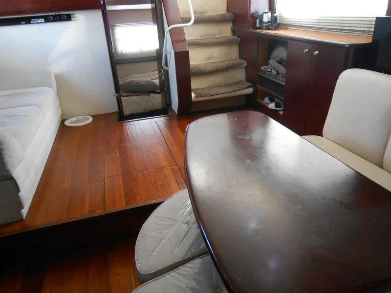 Slide: The Image of Interior of 1999 Silverton 352 MY yacht with wooden flooring and cozy seating area. - 14