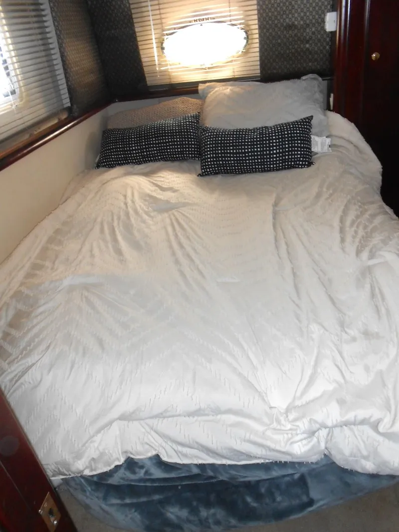 Slide: The Image of 1999 Silverton 352 MY yacht bedroom with cozy bedding and pillows. - 17