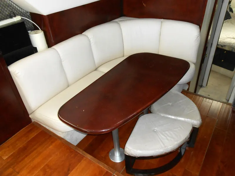 Slide: The Image of 1999 Silverton 352 MY yacht interior with white leather seating and wooden table. - 9