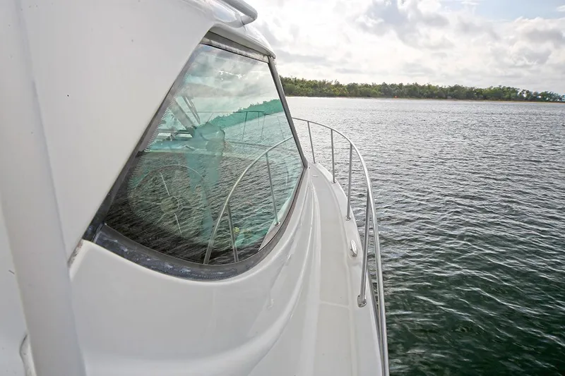 Slide: The Image of 2007 Tiara Yachts 3900 Sovran cruising on calm waters near a forested shoreline. - 11