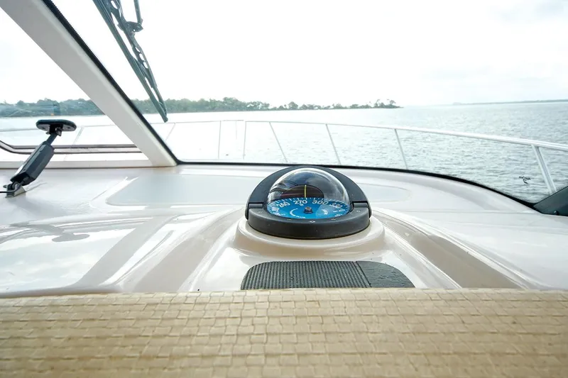 Slide: The Image of 2007 Tiara Yachts 3900 Sovran helm with compass, overlooking serene waters. - 36