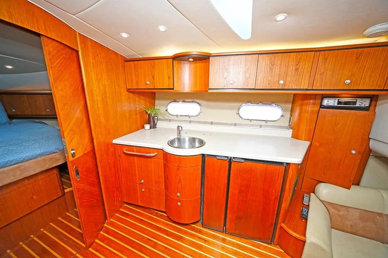 Slide: The Image of 2007 Tiara Yachts 3900 Sovran interior with wooden cabinetry and compact kitchenette. - 47