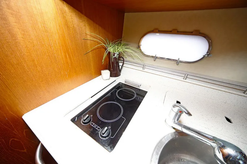 Slide: The Image of 2007 Tiara Yachts 3900 Sovran kitchen with stove, sink, and porthole window. - 48