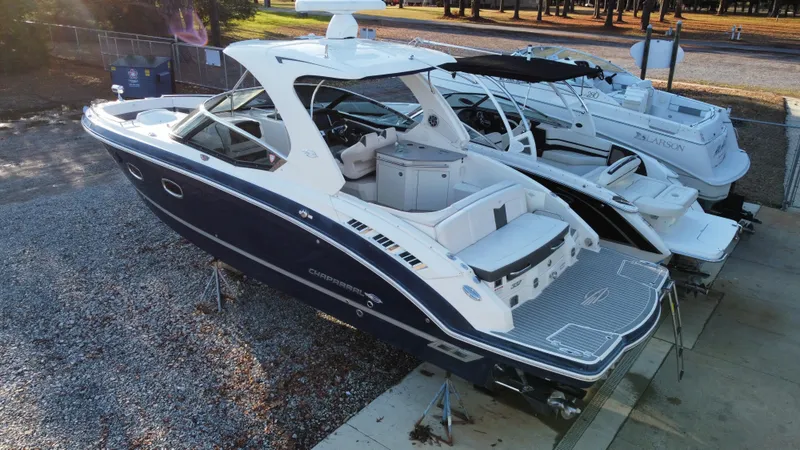 Slide: The Image of 2016 Chaparral 337SSX boat in a marina, side view, parked on gravel. - 11