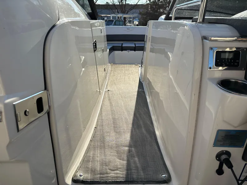 Slide: The Image of 2016 Chaparral 337SSX boat interior walkway with carpet and seating area. - 24