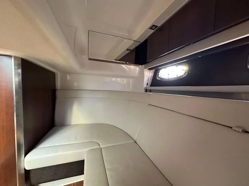Slide: The Image of Interior cabin of 2016 Chaparral 337SSX boat with white seating and window. - 46