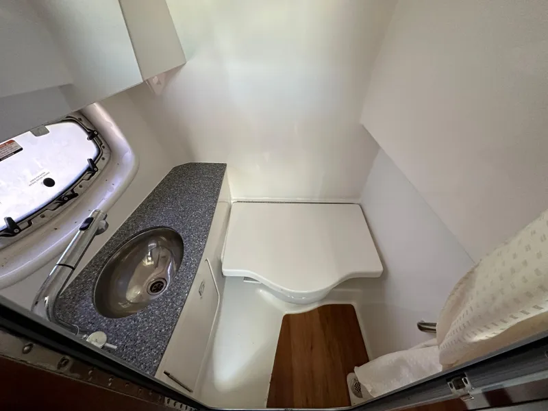 Slide: The Image of 2016 Chaparral 337SSX boat bathroom with sink, countertop, and compact toilet. - 49