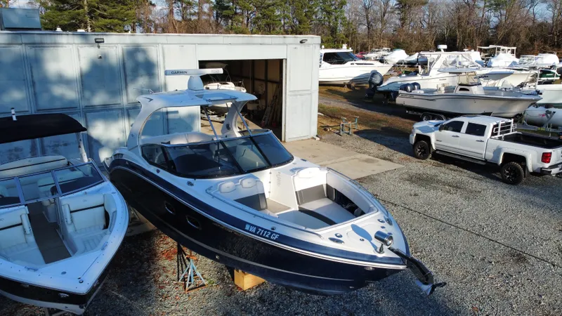 Slide: The Image of 2016 Chaparral 337SSX boat in a marina with other vessels and a truck nearby. - 9