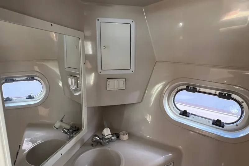 Slide: The Image of 2001 Four Winns 268 Vista boat bathroom with sink, mirror, and porthole window. - 16