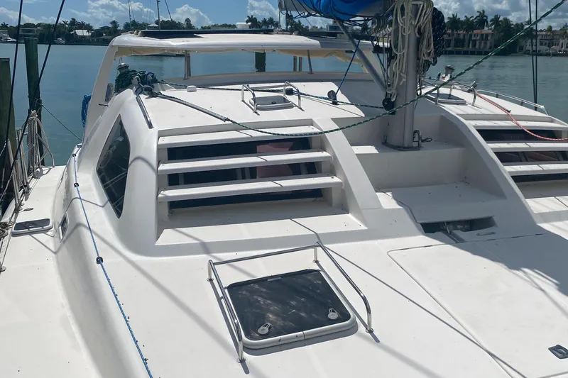 Slide: The Image of 2003 Leopard 38 catamaran deck with hatches and rigging, docked by the water. - 14
