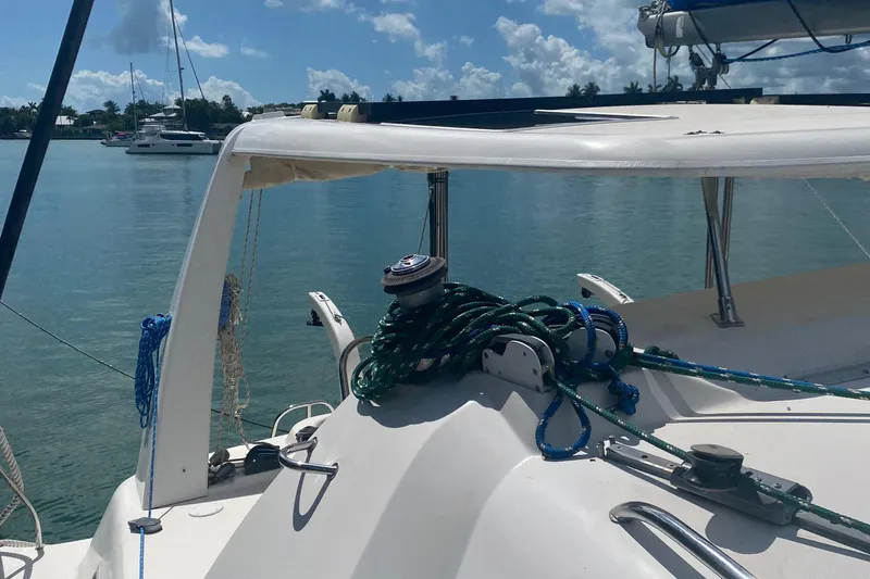 Slide: The Image of 2003 Leopard 38 catamaran deck with ropes, docked in a serene marina setting. - 16