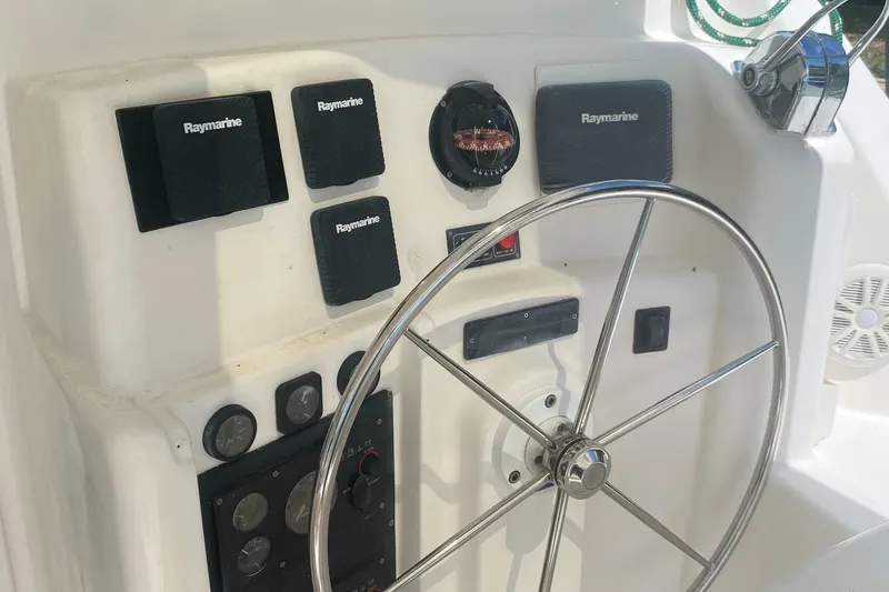 Slide: The Image of Steering wheel and controls of a 2003 Leopard 38 catamaran. - 19