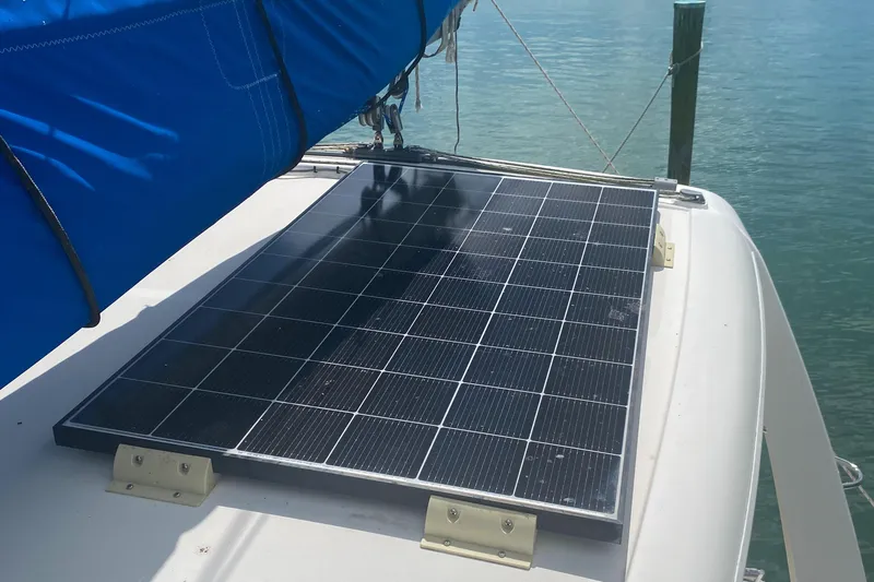 Slide: The Image of Solar panel on 2003 Leopard 38 catamaran deck, near blue sail, docked in clear water. - 23