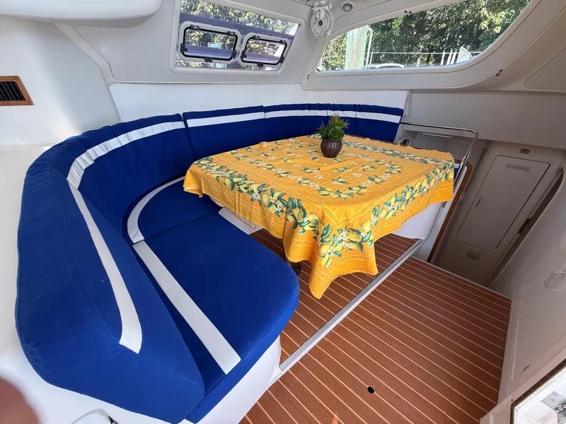 Slide: The Image of Interior of 2003 Leopard 38 yacht with blue seating and yellow tablecloth. - 25