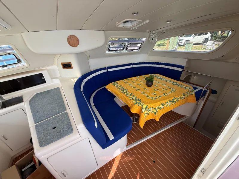 Slide: The Image of Interior of 2003 Leopard 38 yacht with blue seating and yellow tablecloth. - 26