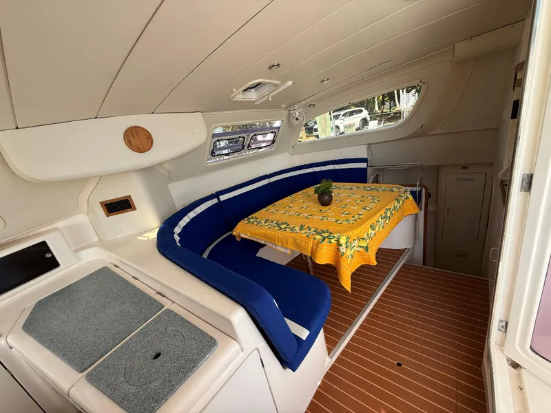 Slide: The Image of Interior of 2003 Leopard 38 yacht with blue seating and yellow tablecloth. - 27