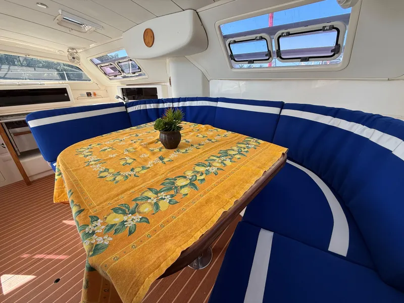 Slide: The Image of Interior of 2003 Leopard 38 yacht with blue seating and yellow floral tablecloth. - 28