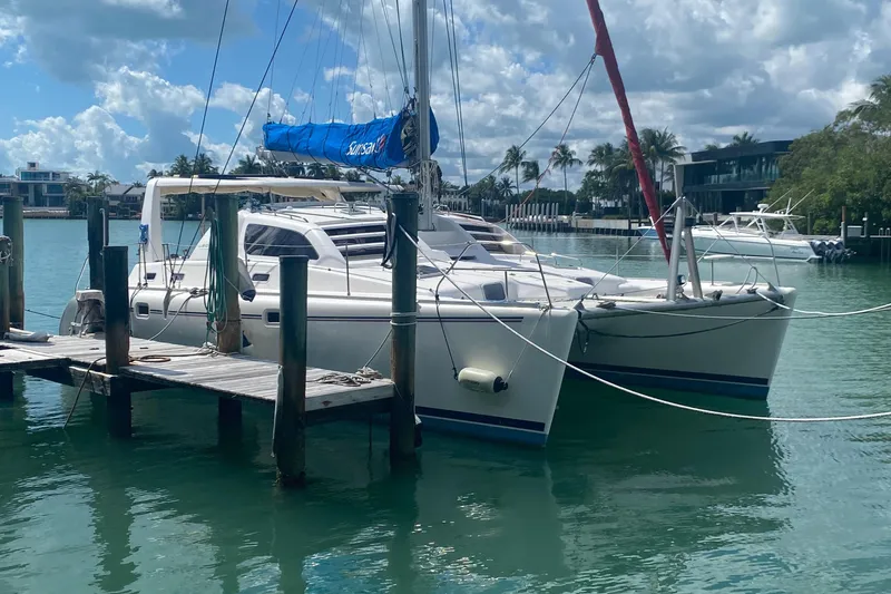 Slide: The Image of 2003 Leopard 38 catamaran docked in a sunny marina with palm trees. - 3