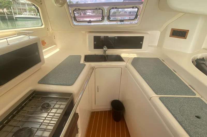 Slide: The Image of Compact kitchen in a 2003 Leopard 38 catamaran with stove, sink, and ample counter space. - 32