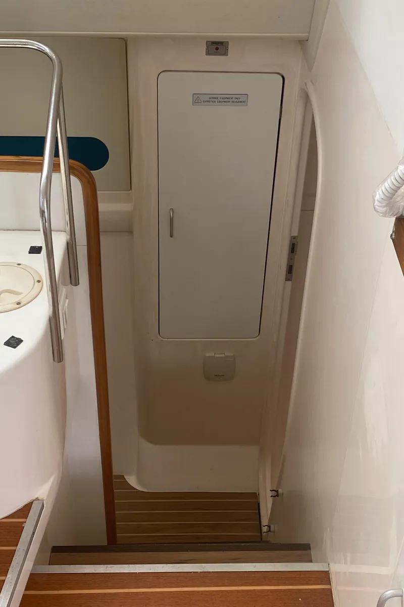 Slide: The Image of Staircase leading to cabin on 2003 Leopard 38 yacht, featuring wooden steps and white walls. - 41