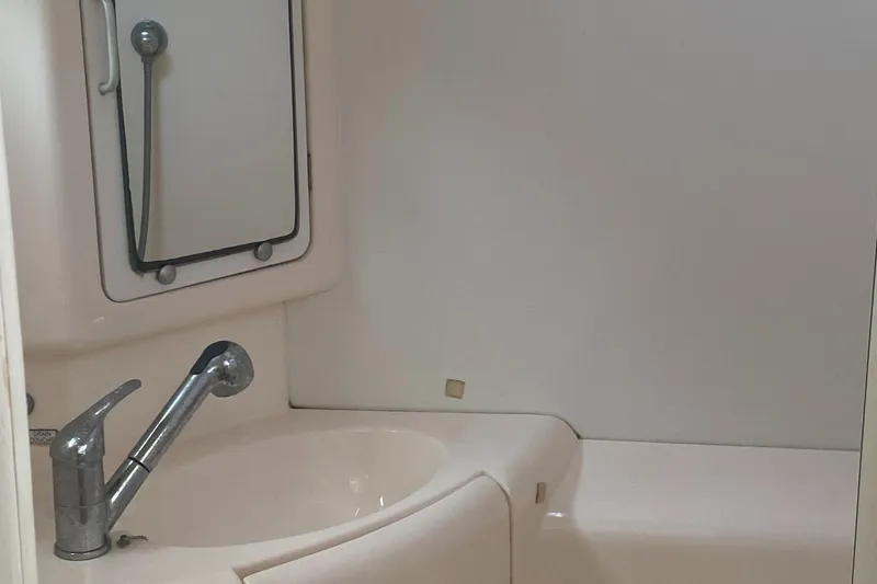 Slide: The Image of Compact bathroom in a 2003 Leopard 38 yacht, featuring a sink and mirror. - 43