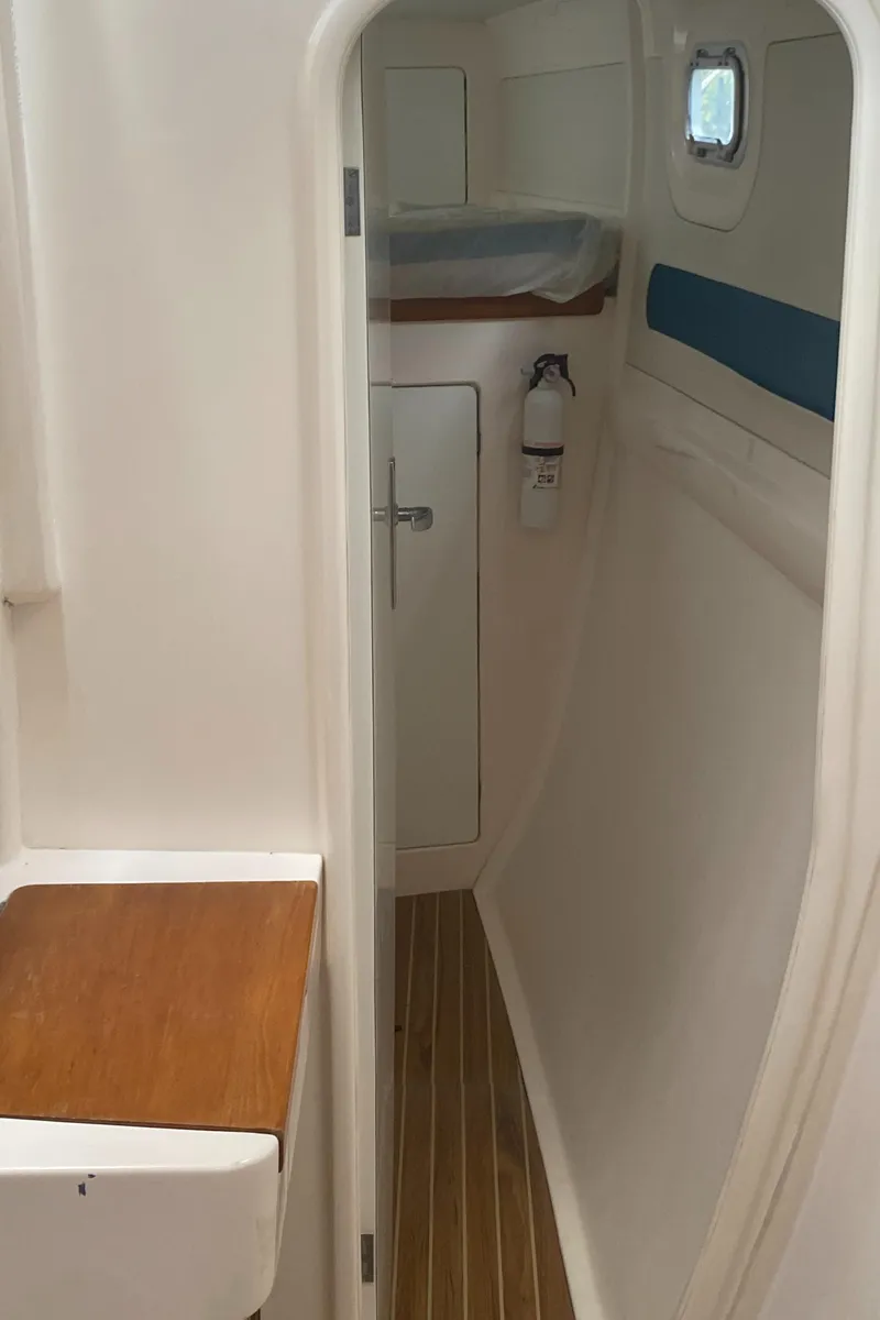 Slide: The Image of Interior of a 2003 Leopard 38 yacht, featuring a narrow hallway and wooden flooring. - 45