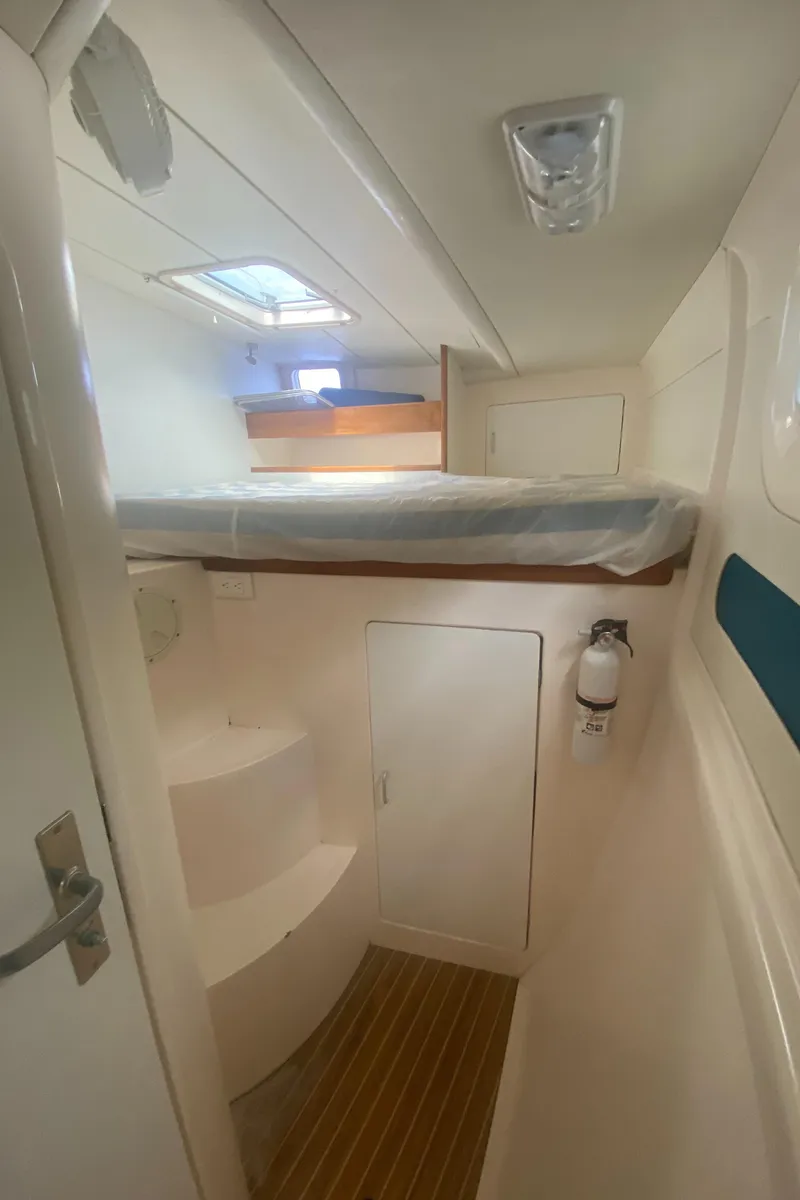 Slide: The Image of 2003 Leopard 38 interior cabin with bed, wooden flooring, and white walls. - 48