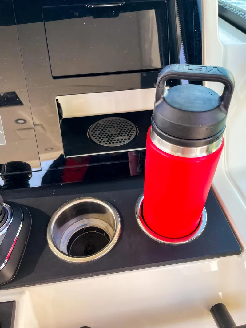 Slide: The Image of Cup holder with red bottle on 2024 Saxdor 320 GTO boat dashboard. - 17