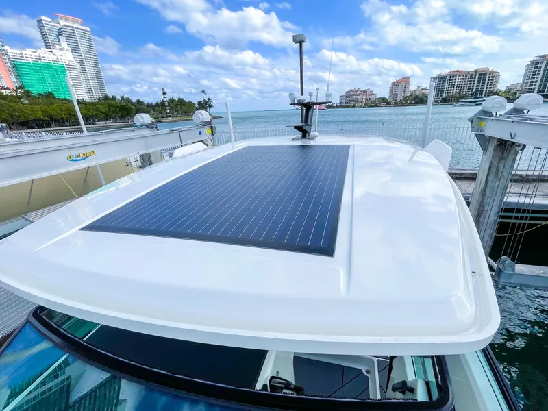 Slide: The Image of 2024 Saxdor 320 GTO with solar panel, docked by waterfront cityscape. - 18