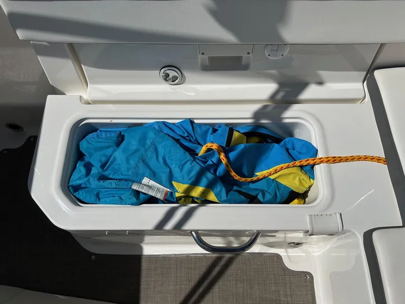 Slide: The Image of 2017 Bayliner VR5 storage compartment with blue tarp and yellow rope. - 8
