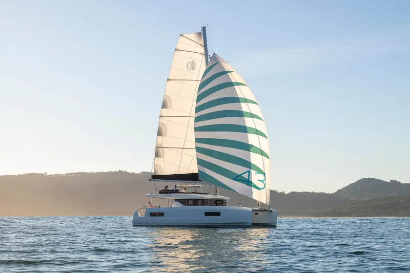 Slide: The Image of 2025 Lagoon 43 catamaran sailing on calm waters at sunset. - 0