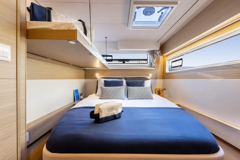 Slide: The Image of Luxurious cabin interior of 2025 Lagoon 43 yacht with modern bedding and skylight. - 43