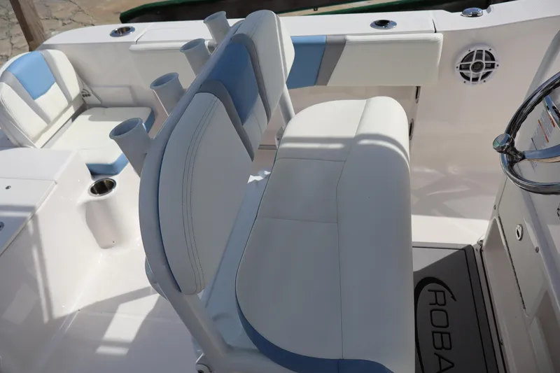 Slide: The Image of 2023 Robalo R200 Center Console boat interior with cushioned seating and rod holders. - 11