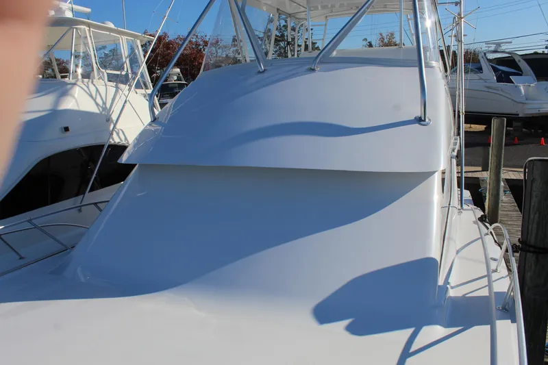 Slide: The Image of 2005 Hatteras 50' Convertible yacht, sleek white exterior, docked in marina. - 10