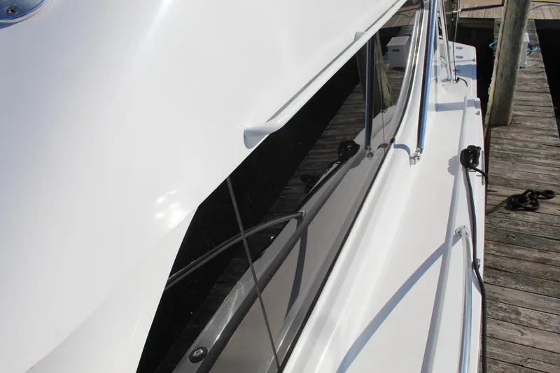Slide: The Image of 2005 Hatteras 50' Convertible yacht docked, showcasing sleek white exterior and polished railings. - 14