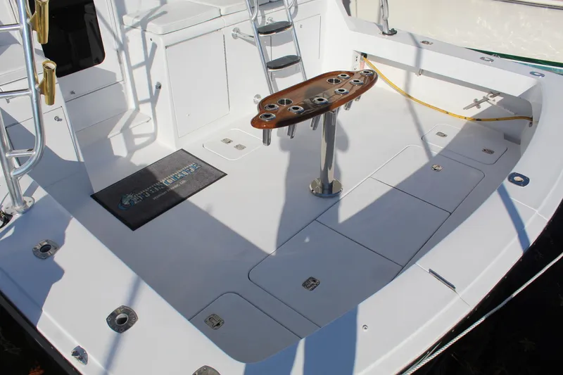 Slide: The Image of 2005 Hatteras 50' Convertible yacht deck with fishing rod holders and ladder. - 20