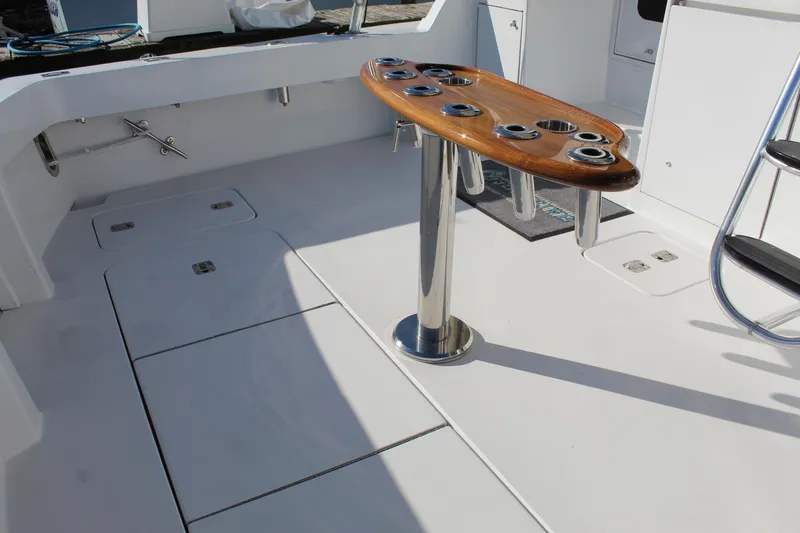 Slide: The Image of 2005 Hatteras 50' Convertible yacht deck with rod holders and storage compartments. - 24