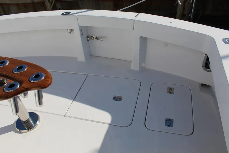 Slide: The Image of 2005 Hatteras 50' Convertible yacht deck with rod holders and storage compartments. - 28