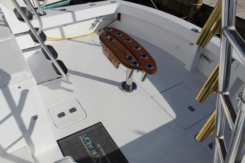 Slide: The Image of 2005 Hatteras 50' Convertible yacht deck with fishing rod holders and ladder. - 29