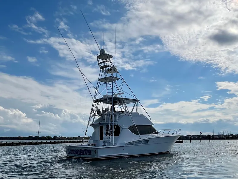 Slide: The Image of 2005 Hatteras 50' Convertible yacht on water under a partly cloudy sky. - 3
