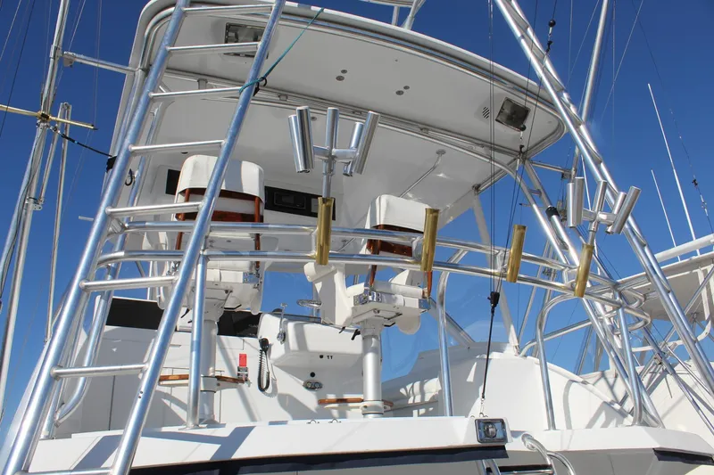 Slide: The Image of 2005 Hatteras 50' Convertible yacht, featuring a sleek tower and fishing equipment against a clear blue sky. - 33
