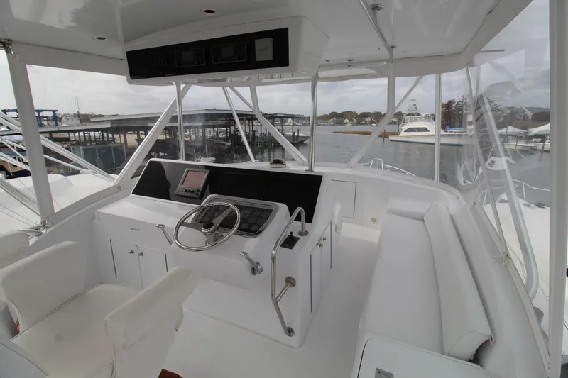 Slide: The Image of 2005 Hatteras 50' Convertible yacht helm with modern controls and waterfront view. - 35