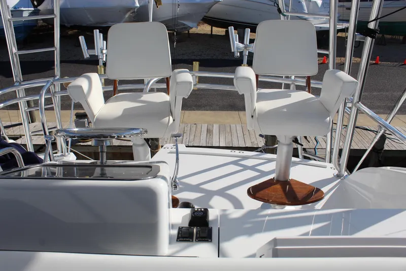 Slide: The Image of 2005 Hatteras 50' Convertible yacht with white captain chairs on deck. - 36