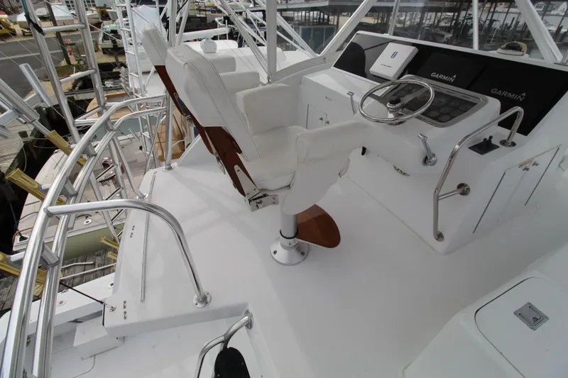 Slide: The Image of Helm of 2005 Hatteras 50' Convertible yacht with white captain's chair and navigation equipment. - 37